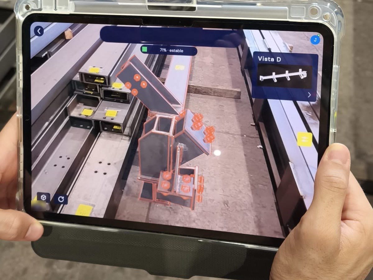 A fitter holds an iPad over steel beams and sees the assembly model overlaid